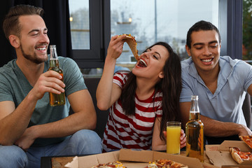 Group of friends having fun party with delicious pizza in cafe