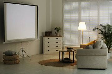 Stylish room with modern video projector and comfortable sofa