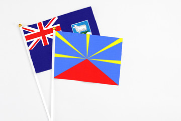 Reunion and Falkland Islands stick flags on white background. High quality fabric, miniature...