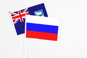 Russia and Falkland Islands stick flags on white background. High quality fabric, miniature national flag. Peaceful global concept.White floor for copy space.