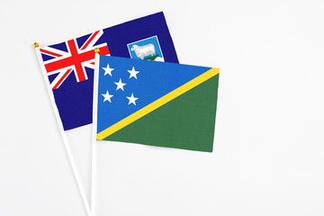 Solomon Islands and Falkland Islands stick flags on white background. High quality fabric, miniature national flag. Peaceful global concept.White floor for copy space.