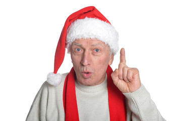 Portrait of senior man in Santa hat isolated pointing up