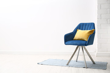 Comfortable armchair with cushion indoors. Space for text