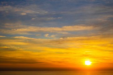 Naklejka na ściany i meble Beautiful and peaceful golden blue sunset or sunrise over the ocean.