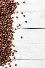 Aromatic coffee beans on white wooden table. Top view