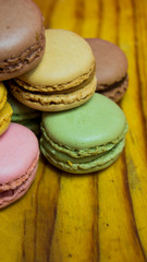 Colored macarons isolated on wooden dish, typical French dish