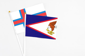 American Samoa and Faroe Islands stick flags on white background. High quality fabric, miniature national flag. Peaceful global concept.White floor for copy space.