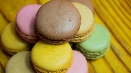 Colored macarons isolated on wooden dish, typical French dish