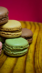 Colored macarons isolated on wooden dish, typical French dish