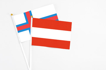 Austria and Faroe Islands stick flags on white background. High quality fabric, miniature national flag. Peaceful global concept.White floor for copy space.