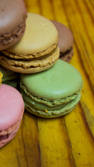 Colored macarons isolated on wooden dish, typical French dish