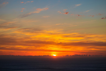 Beautiful and peaceful golden and purple sunset or sunrise over the ocean.