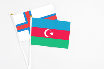 Azerbaijan and Faroe Islands stick flags on white background. High quality fabric, miniature national flag. Peaceful global concept.White floor for copy space.