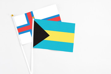 Bahamas and Faroe Islands stick flags on white background. High quality fabric, miniature national flag. Peaceful global concept.White floor for copy space.