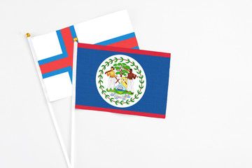 Belize and Faroe Islands stick flags on white background. High quality fabric, miniature national flag. Peaceful global concept.White floor for copy space.