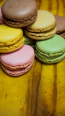 Colored macarons isolated on wooden dish, typical French dish