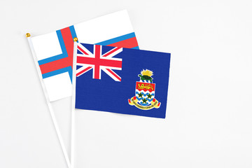 Cayman Islands and Faroe Islands stick flags on white background. High quality fabric, miniature...