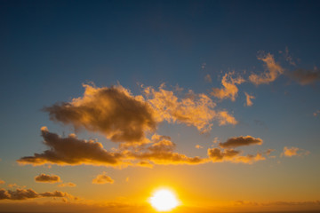 Fototapeta na wymiar Dramatic cloudy golden blue sunset or sunrise over the ocean.