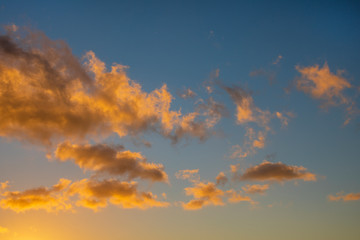 Dramatic cloudy golden blue sunset or sunrise over the ocean.