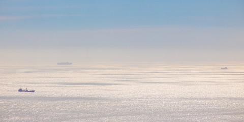 Cargo and fishing ships on a golden blue ocean sunset or sunrise in Cape Town.