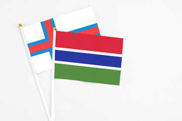 Gambia and Faroe Islands stick flags on white background. High quality fabric, miniature national flag. Peaceful global concept.White floor for copy space.