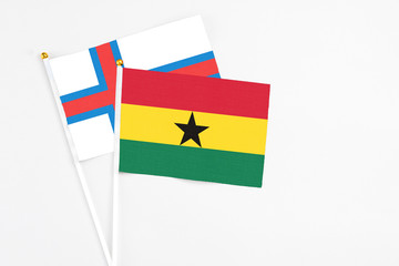 Ghana and Faroe Islands stick flags on white background. High quality fabric, miniature national flag. Peaceful global concept.White floor for copy space.
