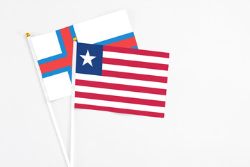 Liberia and Faroe Islands stick flags on white background. High quality fabric, miniature national flag. Peaceful global concept.White floor for copy space.