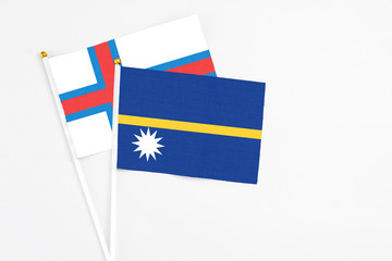 Nauru and Faroe Islands stick flags on white background. High quality fabric, miniature national flag. Peaceful global concept.White floor for copy space.
