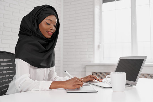 Attactive Muslim Woman In Black Hijab Using Computer