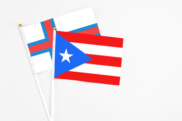 Puerto Rico and Faroe Islands stick flags on white background. High quality fabric, miniature national flag. Peaceful global concept.White floor for copy space.