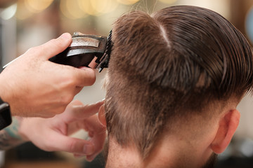 client haircuts at the hairdresser stylist. man cuts hair in a barbershop. 