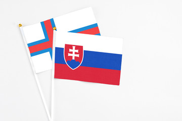 Slovakia and Faroe Islands stick flags on white background. High quality fabric, miniature national flag. Peaceful global concept.White floor for copy space.