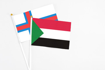 Sudan and Faroe Islands stick flags on white background. High quality fabric, miniature national flag. Peaceful global concept.White floor for copy space.