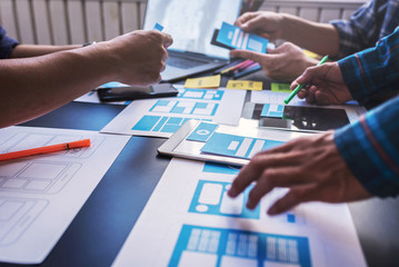 Graphic mobile user experience design teamwork help to design new job in modern office. Design...
