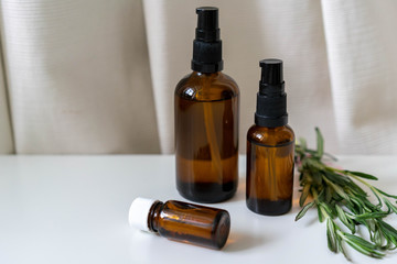 Aromatherapy concept photo with bottles with essential oils and fresh rosemary herb, horizontal...