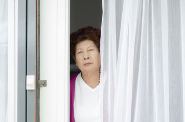Motion blur Asian elderly woman opening home entrance door