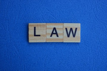 The word from law of brown wooden letters lies on a blue table