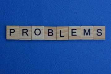 the word problems made of brown wooden letters lies on a blue table