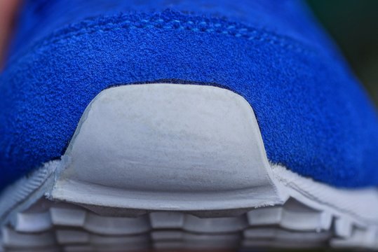 plastic white toe on the sole of a blue suede sneaker