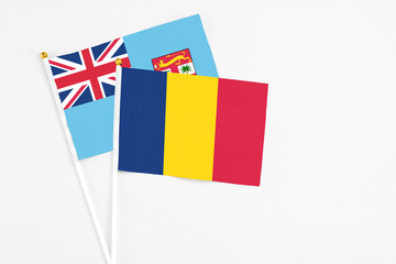 Chad and Fiji stick flags on white background. High quality fabric, miniature national flag. Peaceful global concept.White floor for copy space.