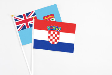 Croatia and Fiji stick flags on white background. High quality fabric, miniature national flag. Peaceful global concept.White floor for copy space.