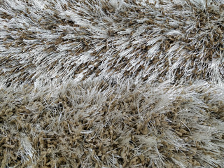 Closeup of warm fluffy and soft texture pattern of beige carpet rug made of different materials for indoor decoration and flooring