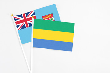 Gabon and Fiji stick flags on white background. High quality fabric, miniature national flag....
