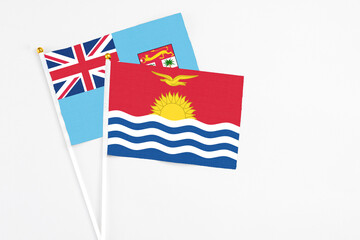 Kiribati and Fiji stick flags on white background. High quality fabric, miniature national flag. Peaceful global concept.White floor for copy space.