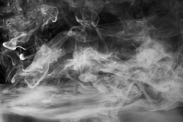 Smoke, fog or steam on black background. Abstraction of transparent cloud of smoke in the air.