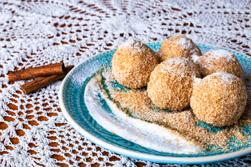 Cottage cheese dumplings with breadcrumbs and powdered sugar on a decorative plate