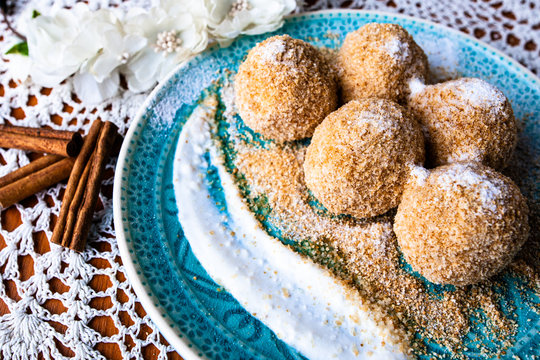 Cottage cheese dumplings with breadcrumbs and powdered sugar on a decorative plate