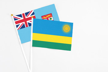 Rwanda and Fiji stick flags on white background. High quality fabric, miniature national flag. Peaceful global concept.White floor for copy space.