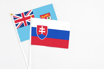Slovakia and Fiji stick flags on white background. High quality fabric, miniature national flag. Peaceful global concept.White floor for copy space.