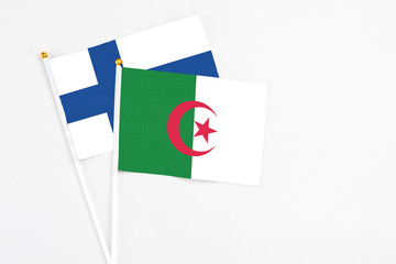 Algeria and Finland stick flags on white background. High quality fabric, miniature national flag. Peaceful global concept.White floor for copy space.